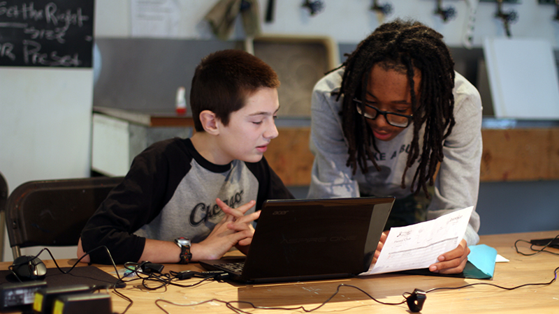 Two students discuss the code for their video games.