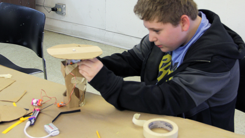 A student builds an interactive kinetic sculpture.